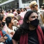 Protesters try to avoid detention by the Delhi police near Connaught Place amid the CJP protest in New Delhi