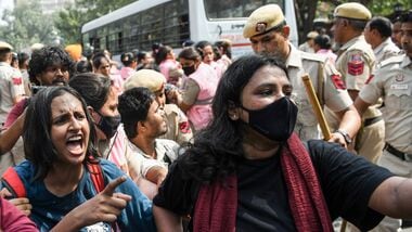 Protesters try to avoid detention by the Delhi police near Connaught Place amid the CJP protest in New Delhi