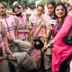 New Delhi, Oct 10 (ANI): Pink Force of the Delhi Police detains a protester near Connaught Place amid the CJP protest, in New Delhi on Saturday. (ANI Photo/Sumit)