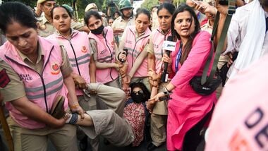 New Delhi, Oct 10 (ANI): Pink Force of the Delhi Police detains a protester near Connaught Place amid the CJP protest, in New Delhi on Saturday. (ANI Photo/Sumit)