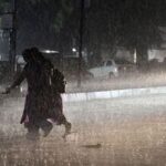 Hyderabad, Oct 30 (ANI): People cross a road amid rain, in Hyderabad on Friday. (ANI Photo)