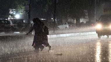 Hyderabad, Oct 30 (ANI): People cross a road amid rain, in Hyderabad on Friday. (ANI Photo)