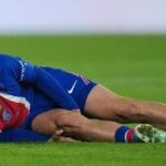 PSG's Khvicha Kvaratskhelia grimaces in pain after a challenges for the ball with Barcelona's Xavi Espart, left, during the Champions League opening phase soccer match between Paris Saint-Germain and FC Barcelona in Paris.