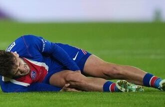 PSG's Khvicha Kvaratskhelia grimaces in pain after a challenges for the ball with Barcelona's Xavi Espart, left, during the Champions League opening phase soccer match between Paris Saint-Germain and FC Barcelona in Paris.