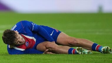 PSG's Khvicha Kvaratskhelia grimaces in pain after a challenges for the ball with Barcelona's Xavi Espart, left, during the Champions League opening phase soccer match between Paris Saint-Germain and FC Barcelona in Paris.