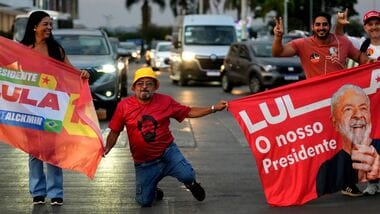 Supporters hold campaign flags depicting Brazilian President Luiz Inacio Lula da Silva, who is running for reelection, during a campaign event on a street in Brasilia, Brazil, Wednesday, Sept. 30, 2026. (AP Photo/Eraldo Peres)