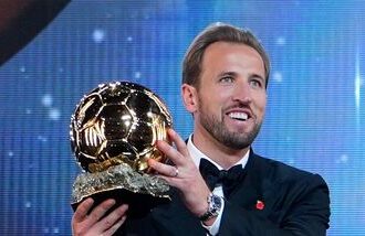 England's soccer player Harry Kane holds the player of the year trophy during the Ballon d'Or ceremony at the London Palladium Theatre.