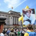 A protestor holds a photo of Britain's former Prince Andrew, outside Buckingham Palace after the King's Birthday Parade 'Trooping the Colour' in London on June 13, 2026. (Photo by JUSTIN TALLIS / AFP)