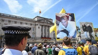 A protestor holds a photo of Britain's former Prince Andrew, outside Buckingham Palace after the King's Birthday Parade 'Trooping the Colour' in London on June 13, 2026. (Photo by JUSTIN TALLIS / AFP)