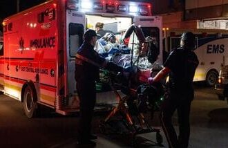 Paramedics load an injured person into an ambulance at the Wainwright Health Centre as injured military members are treated after a fire at Canadian Forces Base Wainwright, outside of Wainwright, Alberta Saturday, Oct. 17, 2026. (John Ulan/The Canadian Press via AP)