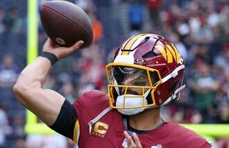 Washington Commanders quarterback Marcus Mariota (8) passes the ball as he warms-up before an NFL football game against Indianapolis Colts in London.