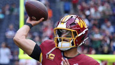Washington Commanders quarterback Marcus Mariota (8) passes the ball as he warms-up before an NFL football game against Indianapolis Colts in London.