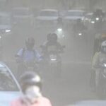 Commuters make their way through a haze-covered and dusty stretch of road as air pollution levels rise in the national capital, New Delhi