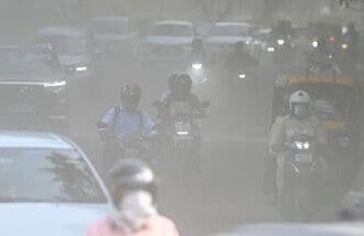 Commuters make their way through a haze-covered and dusty stretch of road as air pollution levels rise in the national capital, New Delhi