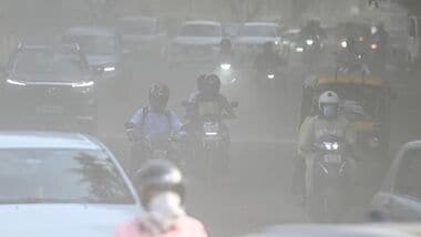 Commuters make their way through a haze-covered and dusty stretch of road as air pollution levels rise in the national capital, New Delhi