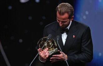 England and Bayern Munich forward Harry Kane looks at the Ballon d'Or trophy after winning it during a ceremony in London on Monday.