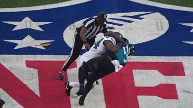 Philadelphia Eagles linebacker Jeremiah Trotter Jr. (54) and Jacksonville Jaguars wide receiver Brian Thomas Jr. (57) fight during the opening kick off at Tottenham Hotspur Stadium. Both players were ejected from the game.