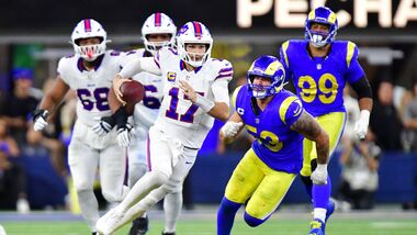 Buffalo Bills quarterback Josh Allen (17) scrambles as Los Angeles Rams linebacker Nate Landman (53) defends during overtime at SoFi Stadium.