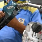 A petrol pump attendant refuels a vehicle at a Bharat Petroleum (BP) gas station in New Delhi