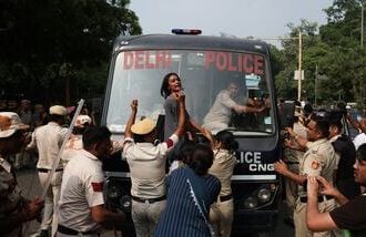 CJP Protest at Jantar Mantar: A protester reacts as she tries to stop the police bus carrying detained protesters during a protest organised by the Cockroach Janta Party (CJP), seeking the resignation of India's Chief Election Commissioner, Gyanesh Kumar, in New Delhi, India, October 10, 2026.