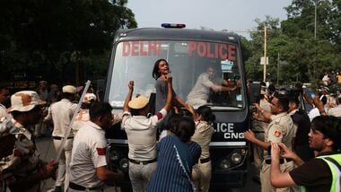 CJP Protest at Jantar Mantar: A protester reacts as she tries to stop the police bus carrying detained protesters during a protest organised by the Cockroach Janta Party (CJP), seeking the resignation of India's Chief Election Commissioner, Gyanesh Kumar, in New Delhi, India, October 10, 2026.