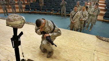FILE - A U.S. Marine pays respects to Lance Cpl. Stephen J. Perez, of San Antonio, Texas, who was killed in a mortar attack on April 13, 2006, at Camp Fallujah, 65 kilometers (40 miles) west of Baghdad, Iraq, Friday, April 28, 2006. (AP Photo/Jacob Silberberg, File)
