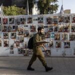 An Israeli soldier walks past pictures of hostages kidnapped during the deadly October 7 attack by the Palestinian Islamist group Hamas, at Dizengoff Square in Tel Aviv, Israel, May 22, 2024. REUTERS/Marko Djurica