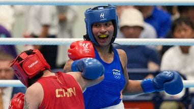 India's Lovlina Borgohain, in blue, and China's Bao Ziyi, in red, fight in their women's 75kg boxing final match at the Asian Games in Nishio, Aichi prefecture, Japan, Friday.