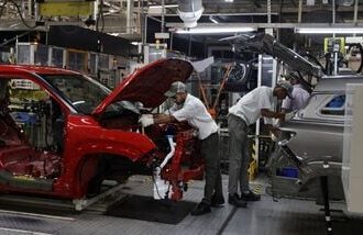Employees assemble different parts onto a car panel at the manufacturing plant of Maruti Suzuki in Manesar. (Reuters)