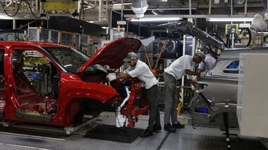 Employees assemble different parts onto a car panel at the manufacturing plant of Maruti Suzuki in Manesar. (Reuters)