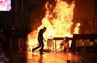 A barricade of cardboards and trash is set on fire as demonstrators clash with Police during an anti-government protest organized by the Italia in Piazza movement, at Piazza Duomo in Milan, on October 17, 2026.