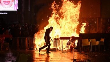 A barricade of cardboards and trash is set on fire as demonstrators clash with Police during an anti-government protest organized by the Italia in Piazza movement, at Piazza Duomo in Milan, on October 17, 2026.