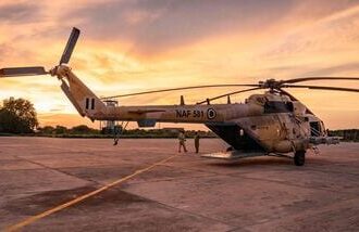 TOPSHOT - A general view of a Nigerian Air Force helicopter parked on the tarmac of the Maiduguri Air Force Baseb as the sun sets on August 2, 2026. Northeast Nigeria has been gripped by an Islamist extremist insurgency since 2009, first by Boko Haram, then its offshoot and rival, the Islamic State West Africa Province (ISWAP). The groups have since last year stepped up reported attacks on villages, police stations and workers such as loggers and fishermen, as well as military bases, killing several senior army officers. The upsurge in attacks prompted President Bola Tinubu to declare a nationwide state of emergency in 2025 (Photo by AFP)