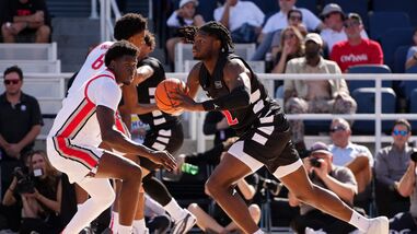 Jayden Hastings #22 of the Cincinnati Bearcats passes the ball while being guarded by Josh Ojianwuna #17 of the Ohio State Buckeyes in the first half of an exhibition game during the 2026 CareSource Invitational at the Lindner Family Tennis Center.