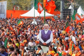 New Delhi: BJP supporters with a cut-out of PM Narendra Modi during the oath ceremony of the Delhi government at Ramlila Maidan, in New Delhi, Thursday, Feb. 20, 2025. (PTI Photo/Manvender Vashist Lav) (PTI02_20_2025_000247A)