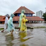 Kochi: Children cover themselves as they move on a waterlogged road following rainfall, near Sree Mahadeva Temple, in Kochi, Kerala, Saturday, Aug. 1, 2026. (PTI Photo)(PTI08_01_2026_000303A)