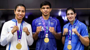 Asian Games 2026 gold medallist boxers, from left, Lovlina Borgohain, Ankush Panghal and Parveen Hooda pose for photographers upon their arrival at the Indira Gandhi International (IGI) Airport, in New Delhi on Sunday.