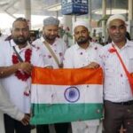 Umrah pilgrims from Gujarat, who were stranded in Saudi Arabia following a Houthi drone and missile attack, hold the Indian national flag upon their arrival at Sardar Vallabhbhai Patel International Airport, in Ahmedabad, Monday.