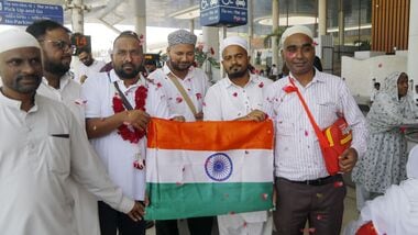 Umrah pilgrims from Gujarat, who were stranded in Saudi Arabia following a Houthi drone and missile attack, hold the Indian national flag upon their arrival at Sardar Vallabhbhai Patel International Airport, in Ahmedabad, Monday.