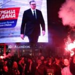 People celebrate after Aleksandar Vucic, leader of the right-wing Serbian Progressive Party (SNS) , seen on the top display, conceded defeat in the parliamentary election in Belgrade, Serbia, Sunday, Oct. 25, 2026. (AP Photo/Armin Durgut)