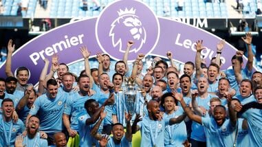 Manchester City manager Pep Guardiola celebrates with the trophy, players and staff after winning the Premier League title. (file photo)
