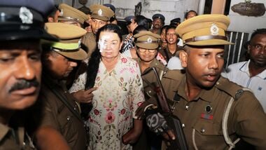 Prison officers escort Shiranthi Rajapaksa, the wife of Sri Lanka's former President Mahinda Rajapaksa, to a prison vehicle outside a magistrate's court in Colombo, Sri Lanka, Wednesday, Oct. 7, 2026. (AP Photo/Lahiru Harshana)