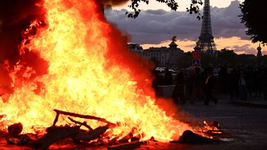A fire is seen with the Eiffel Tower in the background during a demonstration to protest against the ‘high cost of living’, in Paris on October 17, 2026.