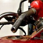 A pump attendant fuels a motorcycle at a petrol station